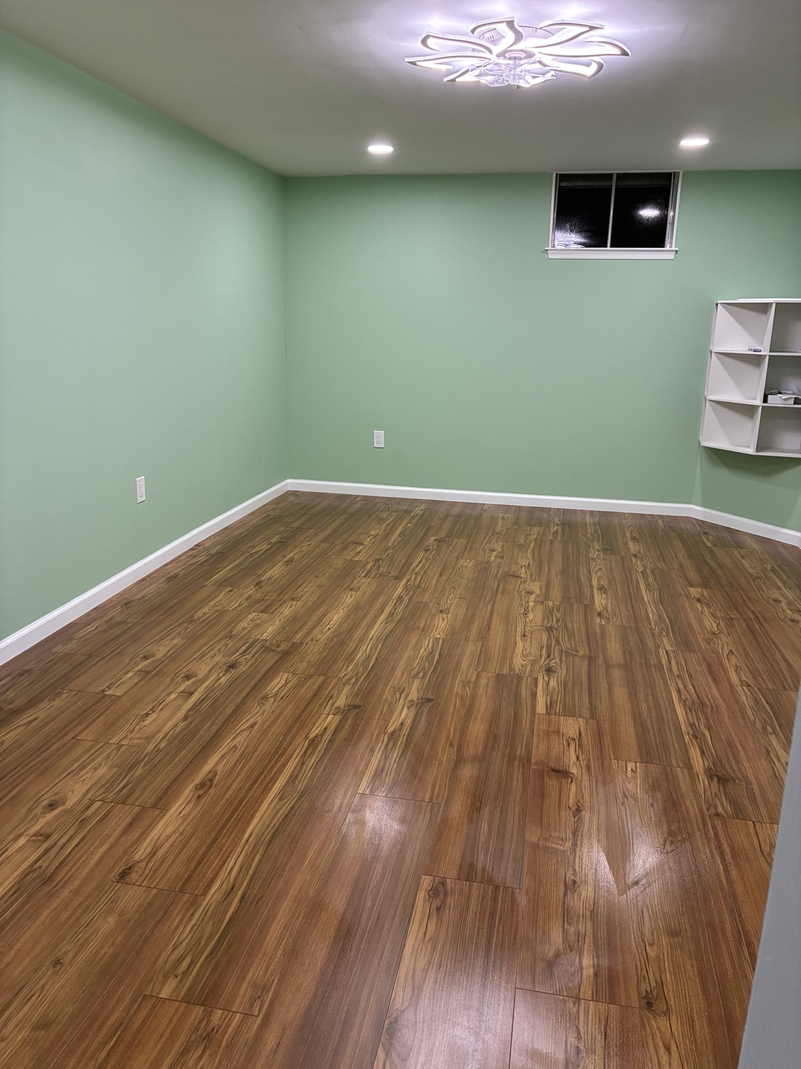 Finished basement room with new walls lighting flooring paint and trim