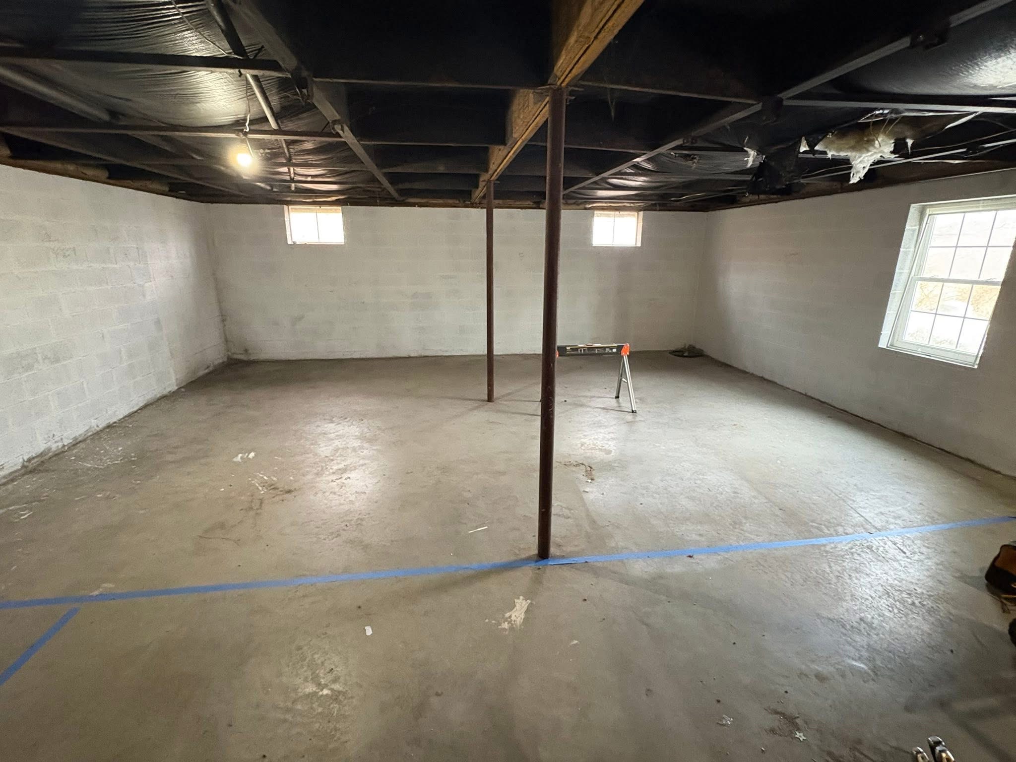 Open basement with concrete block walls before conversion