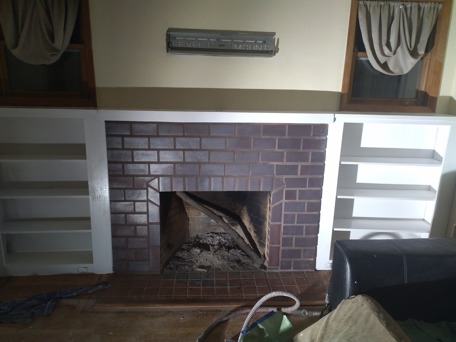 Restored fireplace with white built-in shelving on both sides