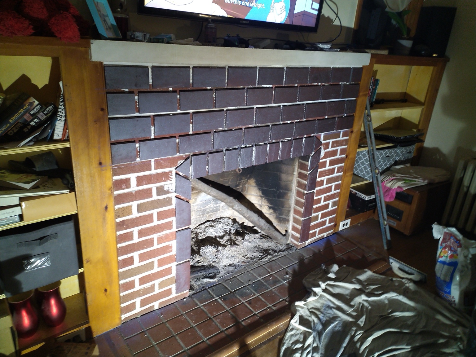 Fireplace during demolition with uneven brick removed