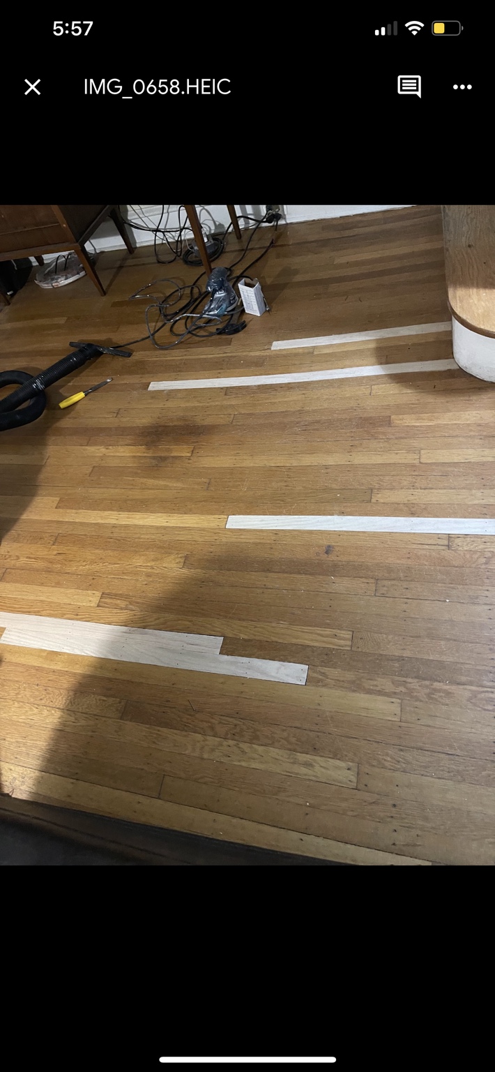 Custom oak strips fitted and nailed into an existing hardwood floor